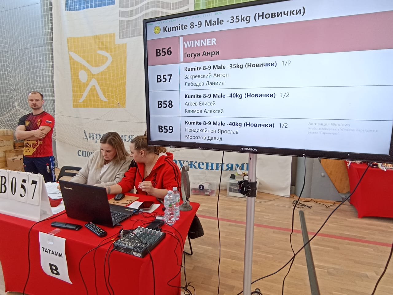 8–9 жасар „Жаңадан бастаушылар“ категориясы, 35 кг-ға дейін: B56 жеңімпазы — Гогуа Анри Кубок побратим турнирінің техникалық орны: кумитэ нәтижелері экраны, ноутбук пен дыбыс пульті бар үстел, B татами