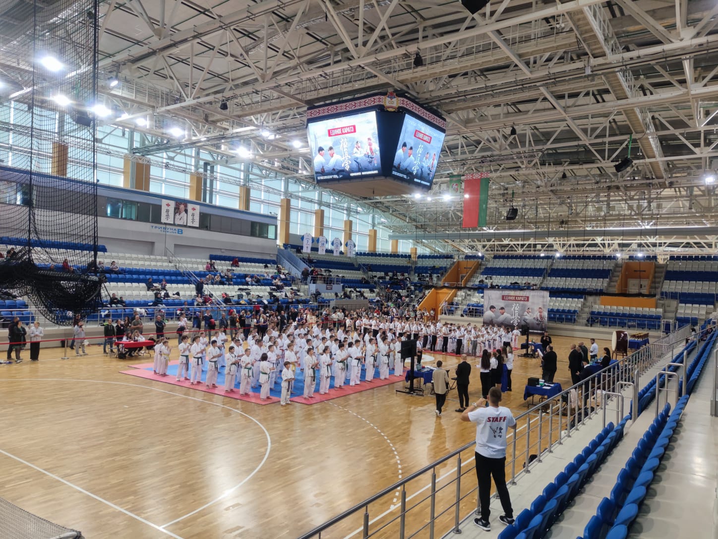„Belarus Open Cup 2023“ тізімі — 794 қатысушы; „Kata 8-9 Female“ категориясы таңдалған Спорт кешеніндегі киокушинкай Біріккен Каратэ турнирінде ақ кимоно киген каратэки, табло және трибунадағы көрермендер