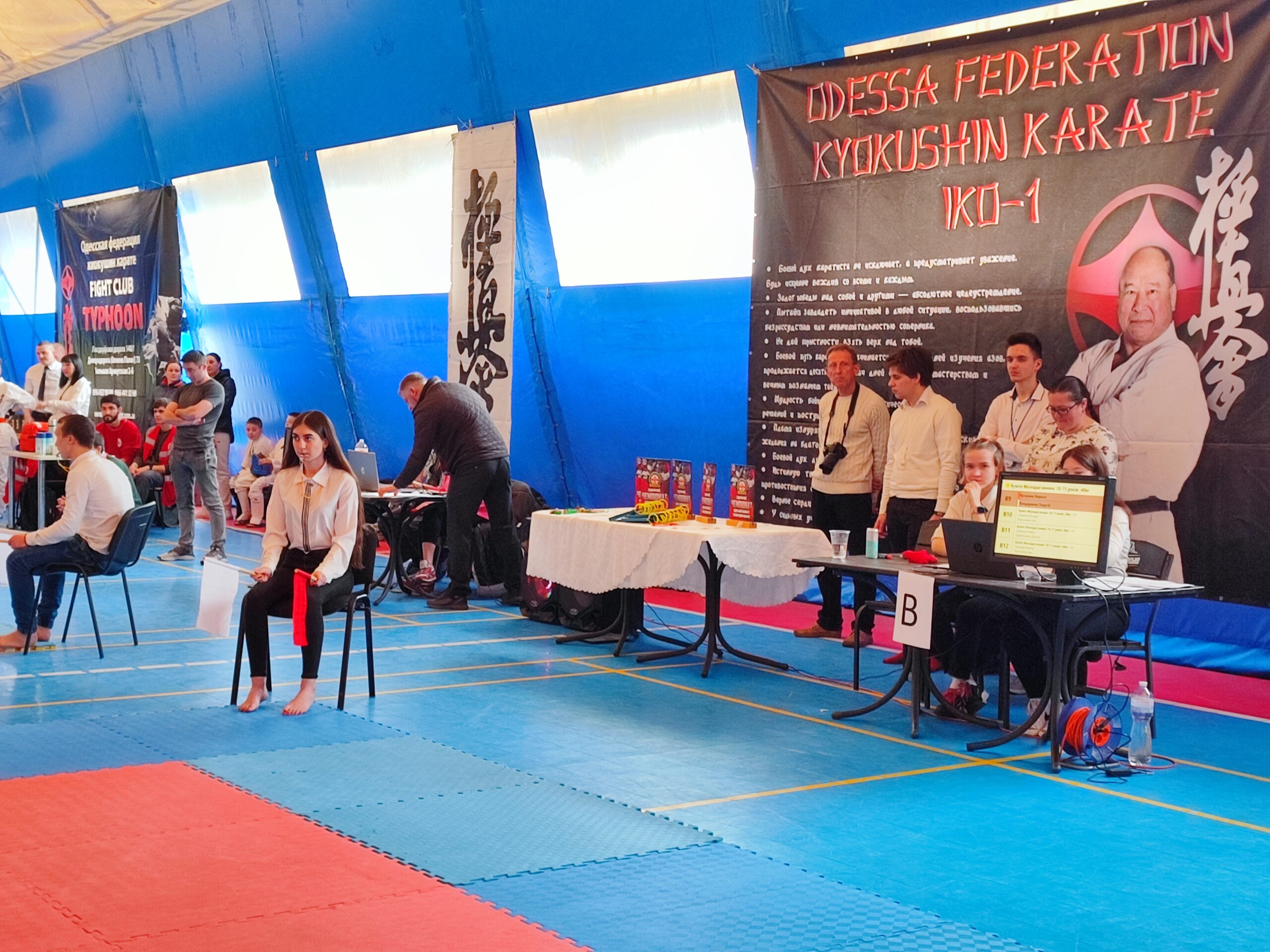 «ODESSA FEDERATION KYOKUSHIN KARATE IKO-1»: B3, B10–B13 экрандары, үстелдегі кубок Одесса облысының ашық киокушинкай чемпионатындағы татамидегі сот аймағы және белгілер