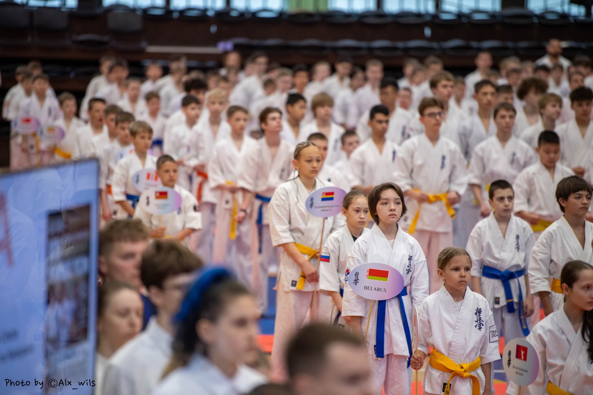 Karateka in white gi with the flags of 19 Russian regions and Belarus at the opening ceremony of the 13th SKKR Championship, Moscow